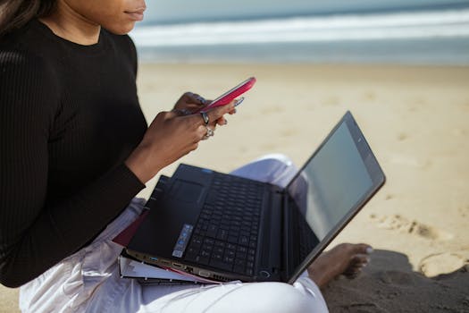 digital nomad working on a laptop at a beach