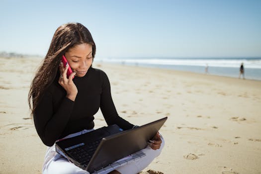 a travel blogger working on a laptop at a beach